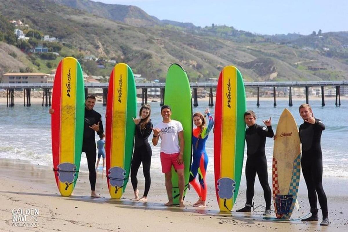 un gruppo di persone in piedi sulla spiaggia con tavole da surf