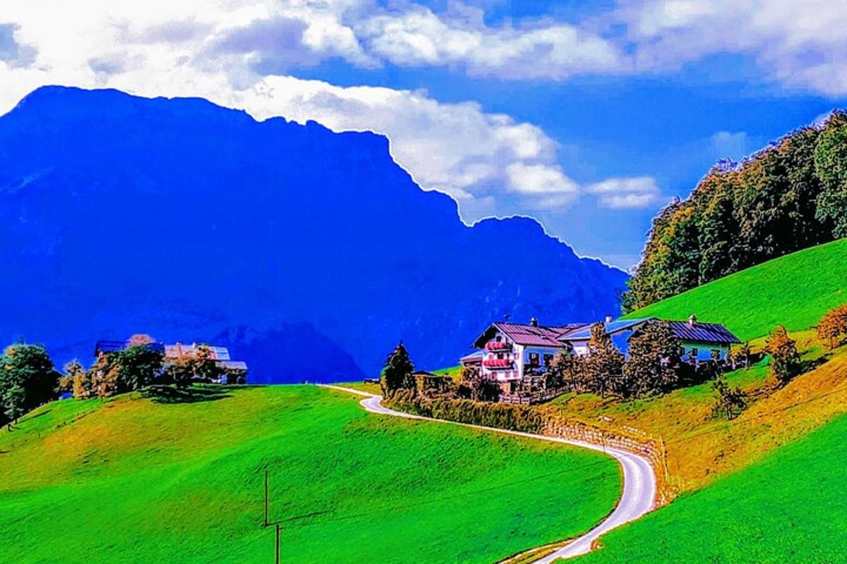 una casa su una collina verde con una strada