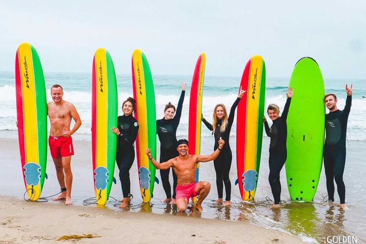 un gruppo di persone in piedi sulla spiaggia con tavole da surf