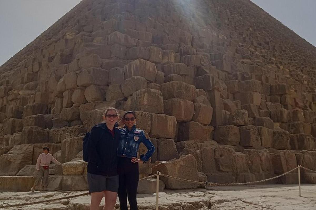 two people standing in front of a pyramid