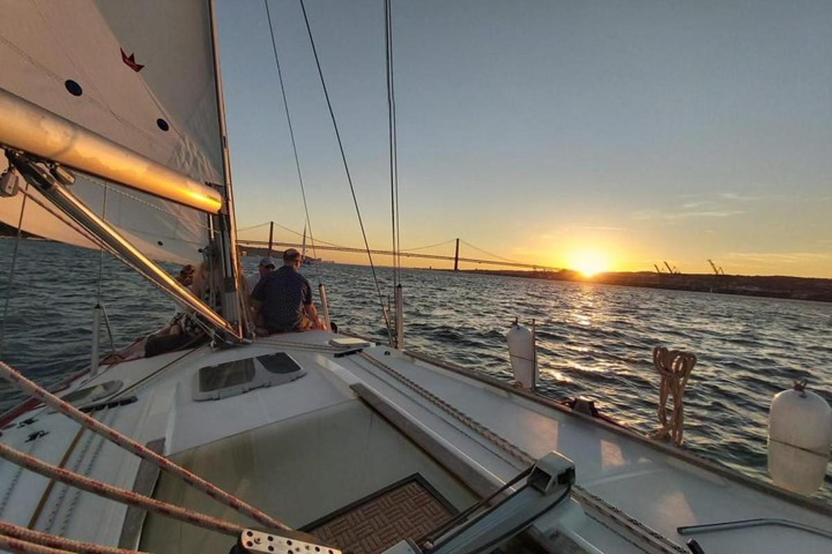 a man on a sail boat in the water with the sunset