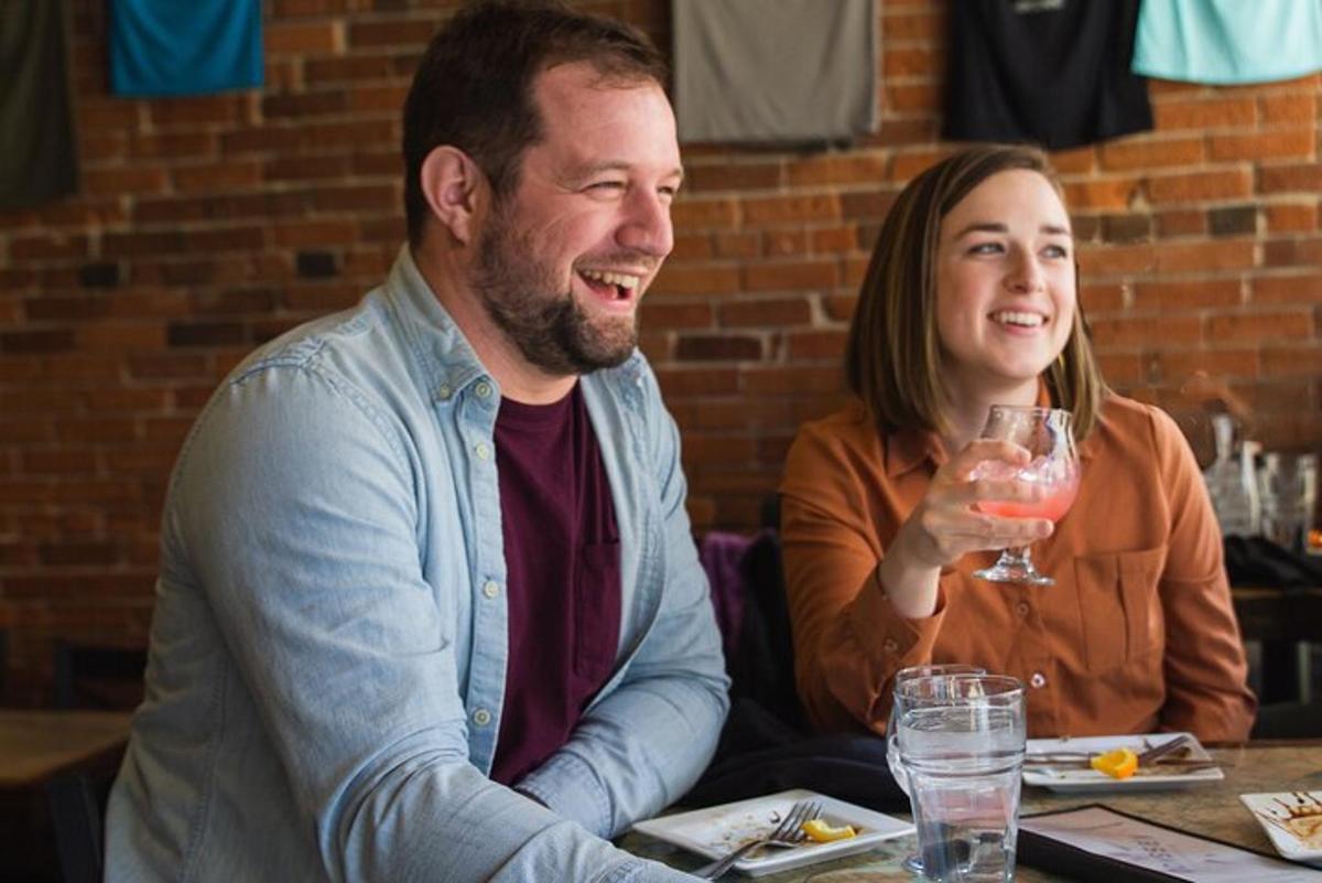 a man and woman sitting at a table with a glass of wine