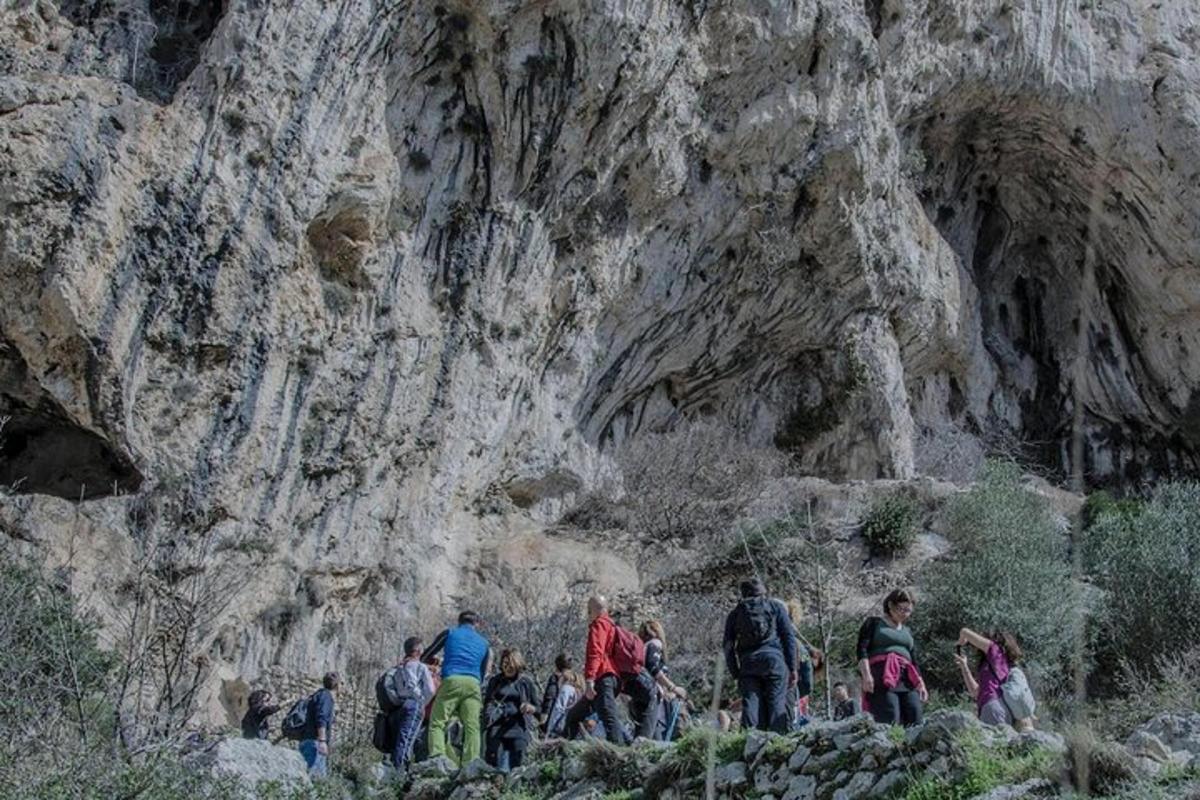 um grupo de pessoas caminhando em frente a uma montanha
