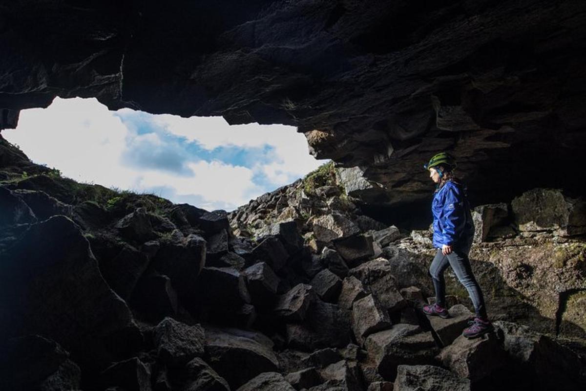 uma pessoa parada em uma caverna sobre algumas rochas