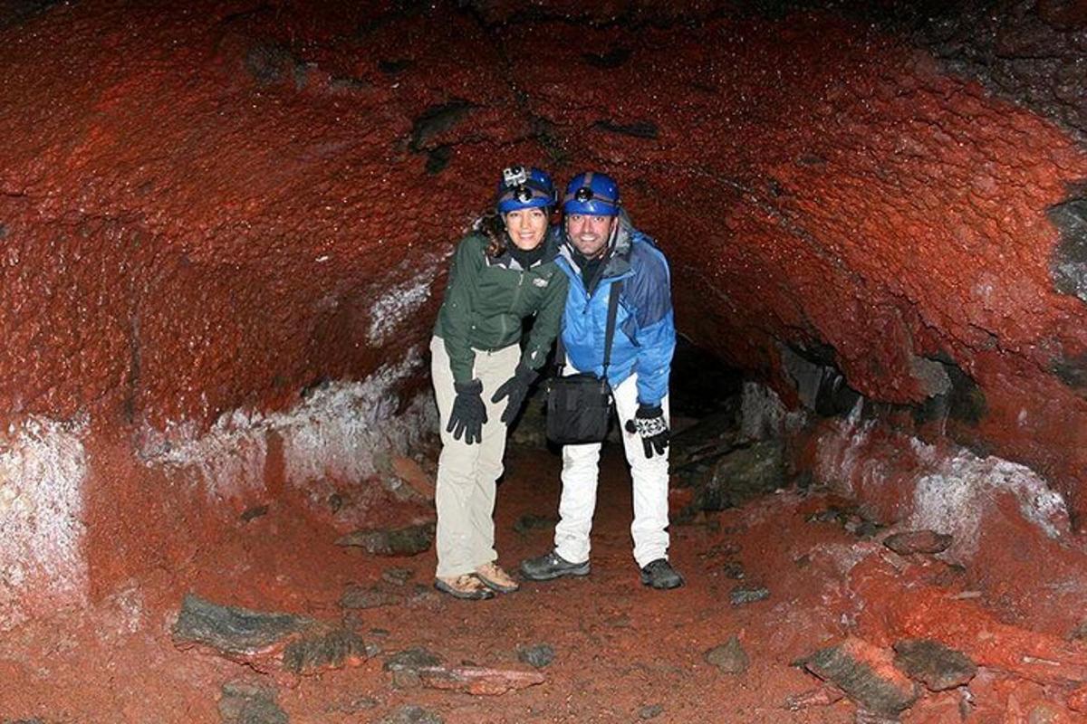 um homem e uma mulher parados em uma caverna
