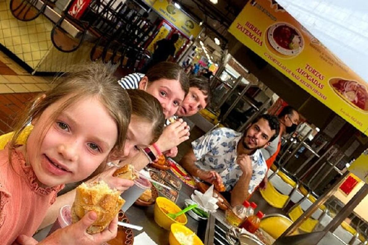 un gruppo di persone sedute a un tavolo che mangiano cibo