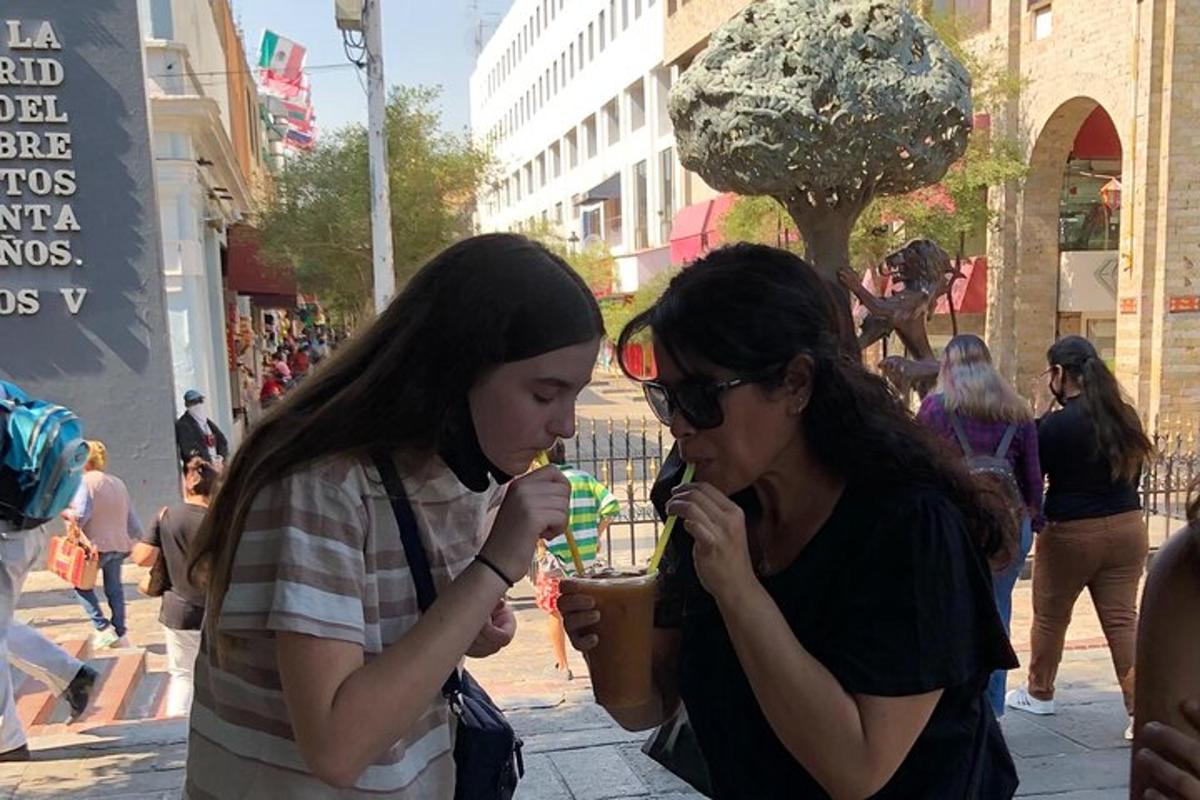 due giovani donne che mangiano cibo in una strada cittadina