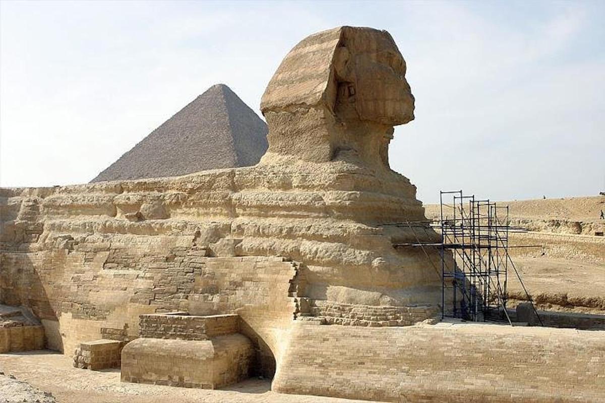 socha před sfingou a pyramidou