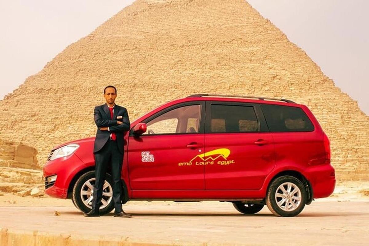 muž stojící vedle červené dodávky před pyramidou
