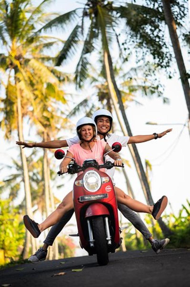 hai người đang đi xe tay ga trên đường