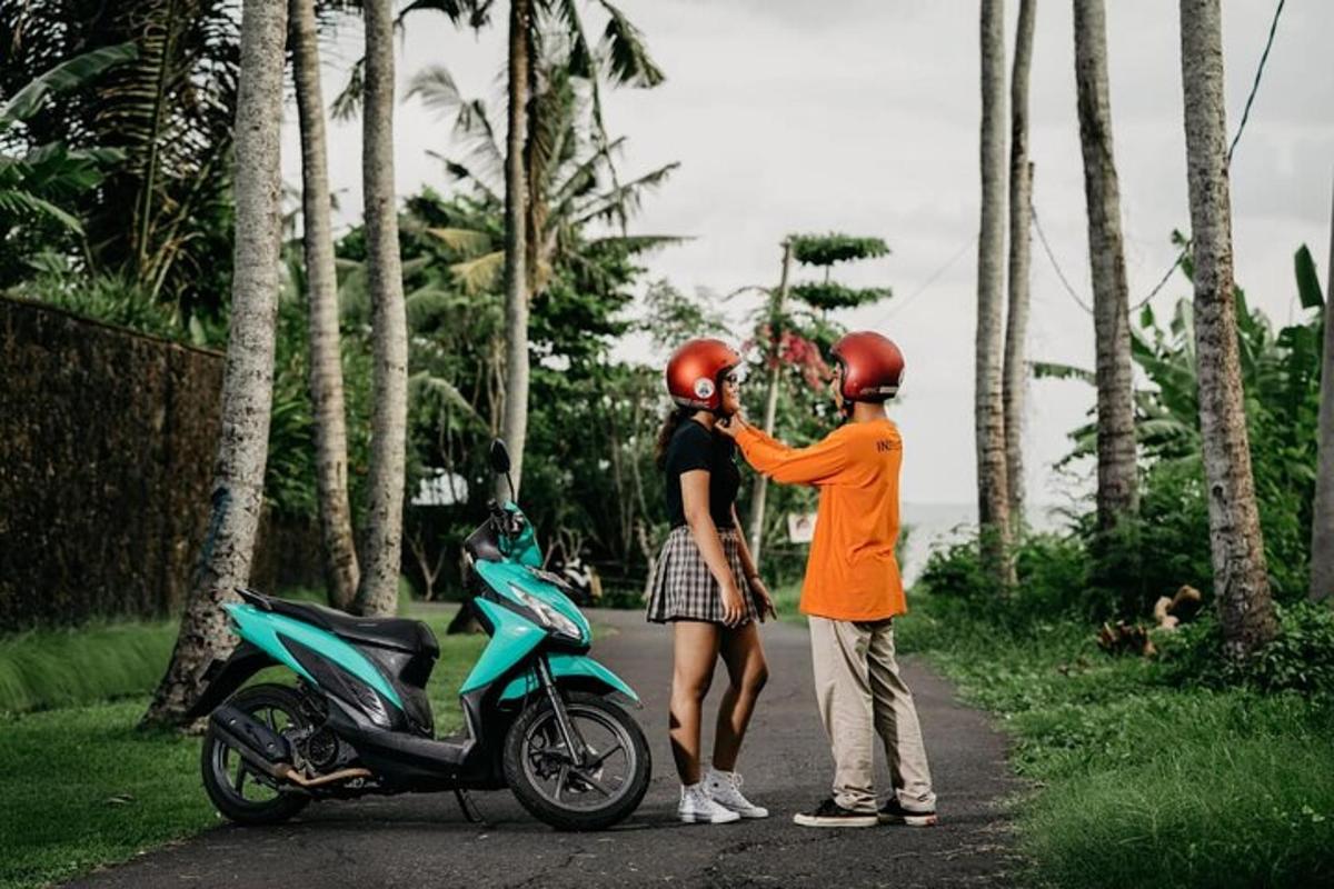 due persone che indossano il casco in piedi accanto a uno scooter