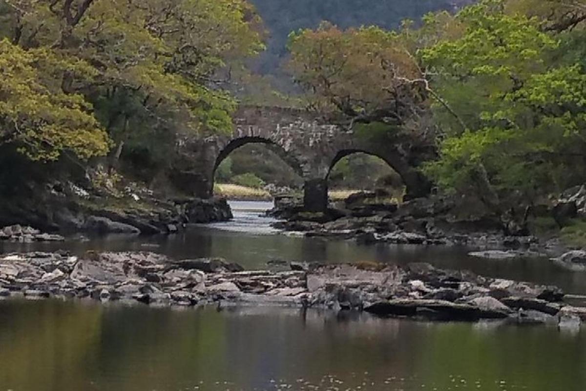 uma velha ponte de pedra sobre um rio com pedras