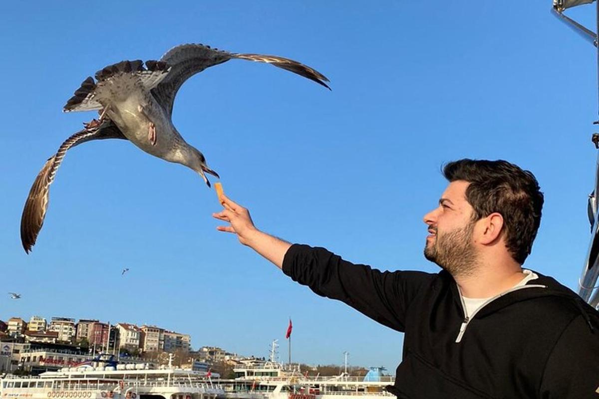 a man feeding a bird with a stick