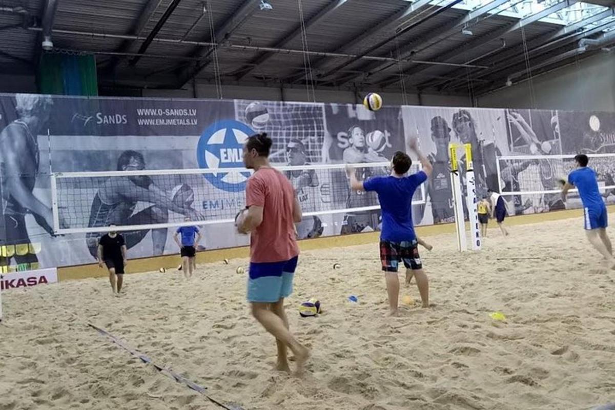 un grup de persones jugant a voleibol a la platja