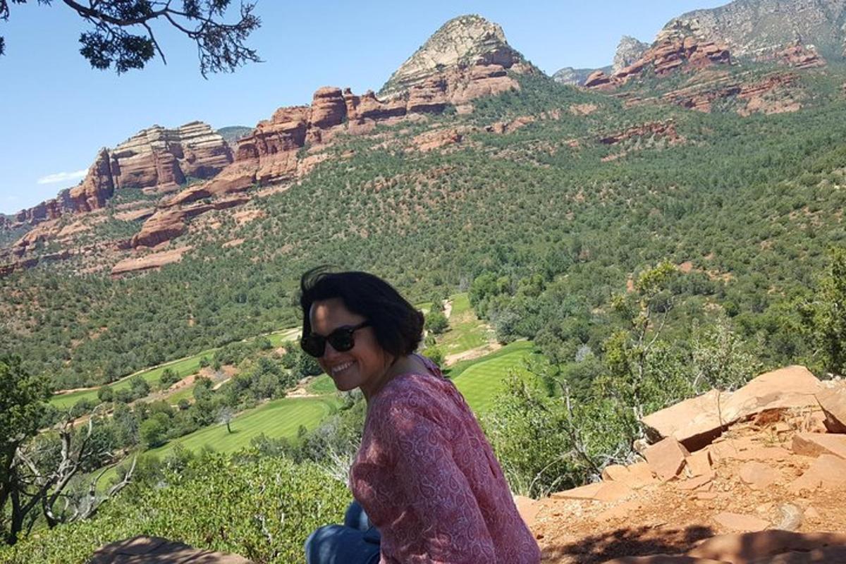 una mujer sentada en la cima de una montaña