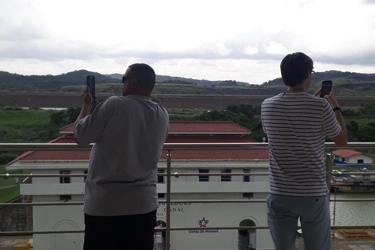 dos homes fent fotos d'un edifici amb els seus telèfons mòbils