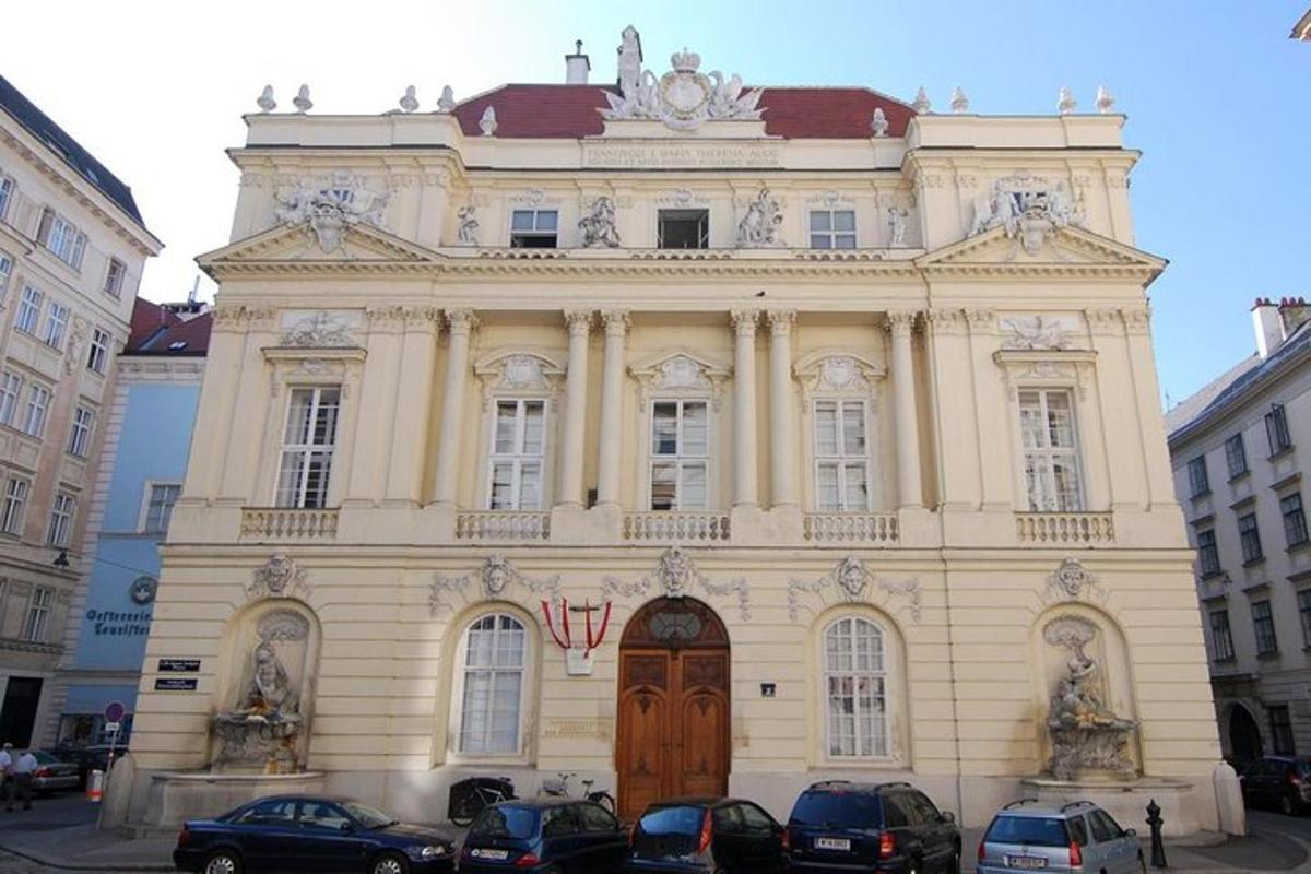 velika stavba z lesenimi vrati in avtomobili parkiranimi pred njo