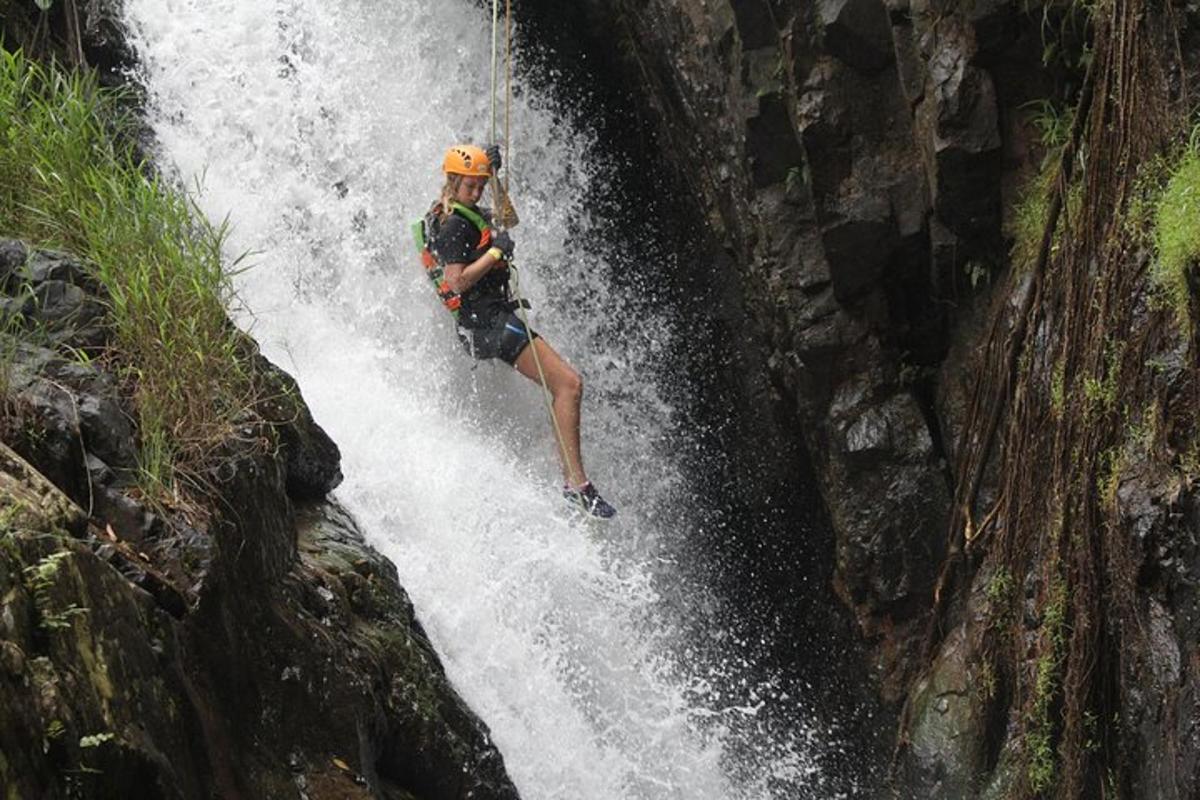 una donna si sta calando in corda doppia da una cascata