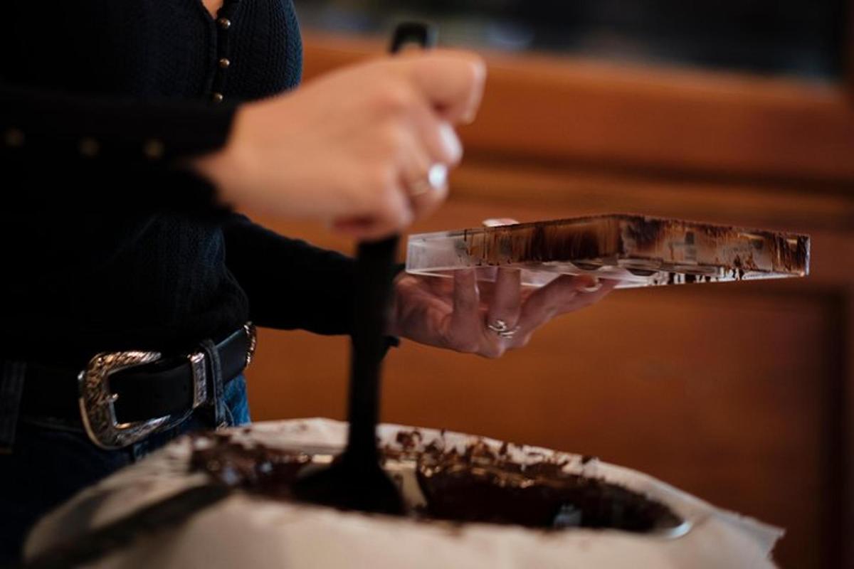 a person holding a glass in front of a cake