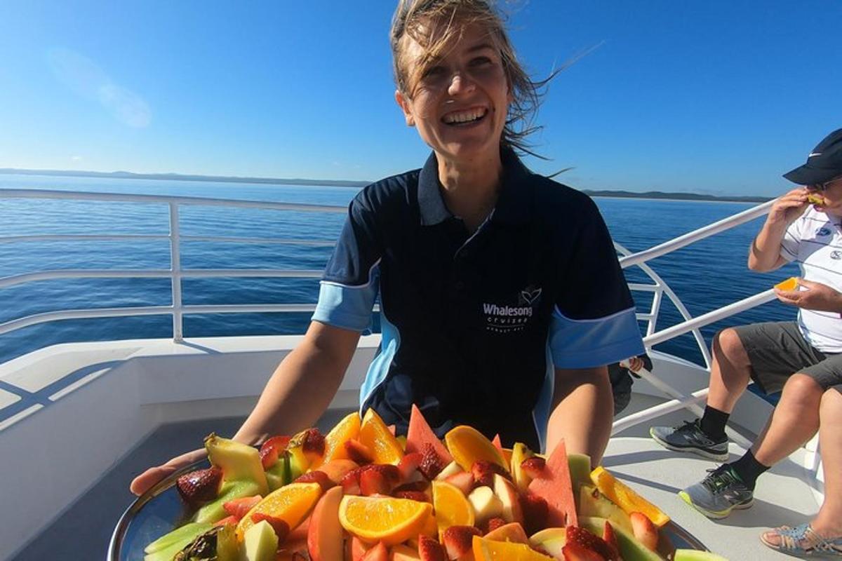 a woman sitting on a boat with a plate of fruit
