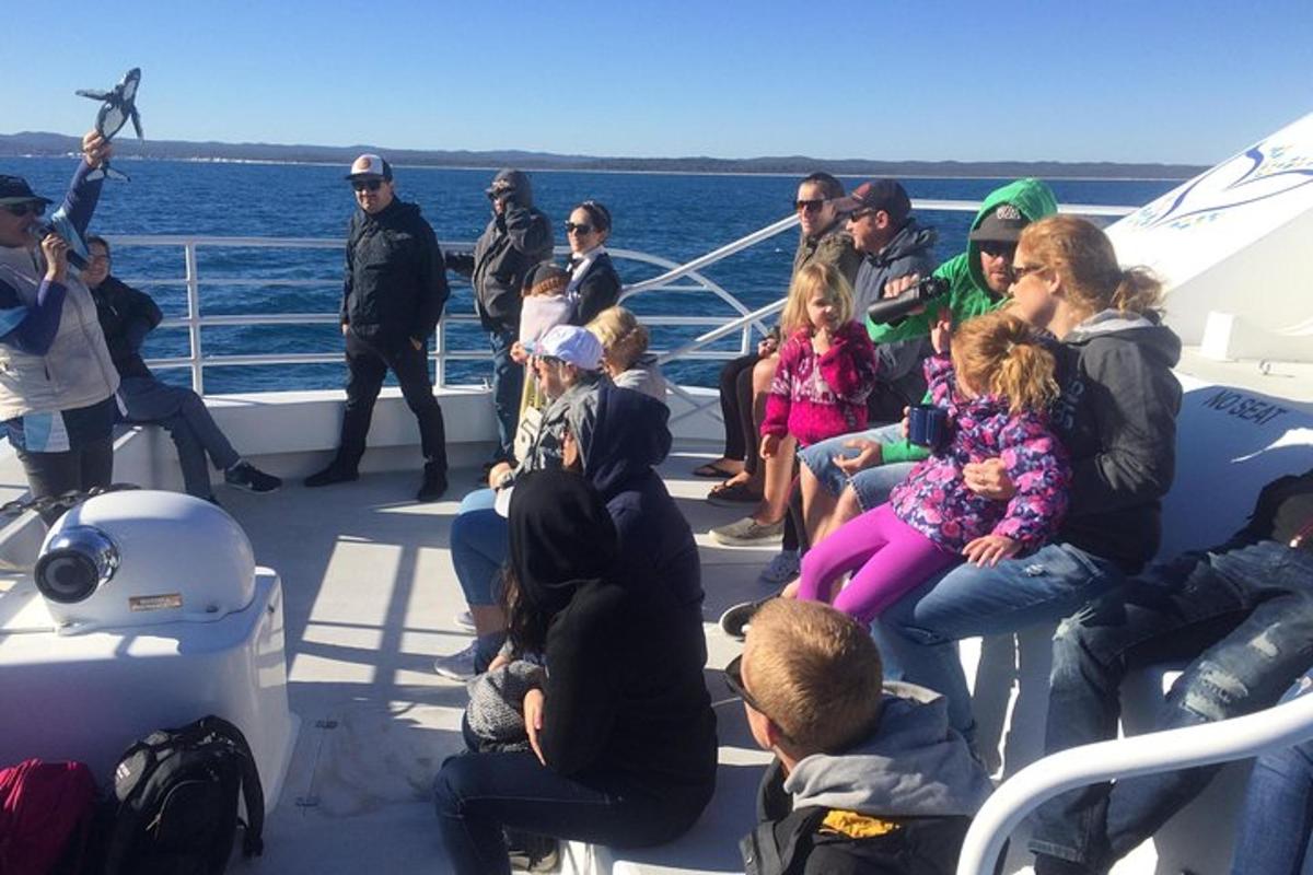 a group of people sitting on the deck of a boat