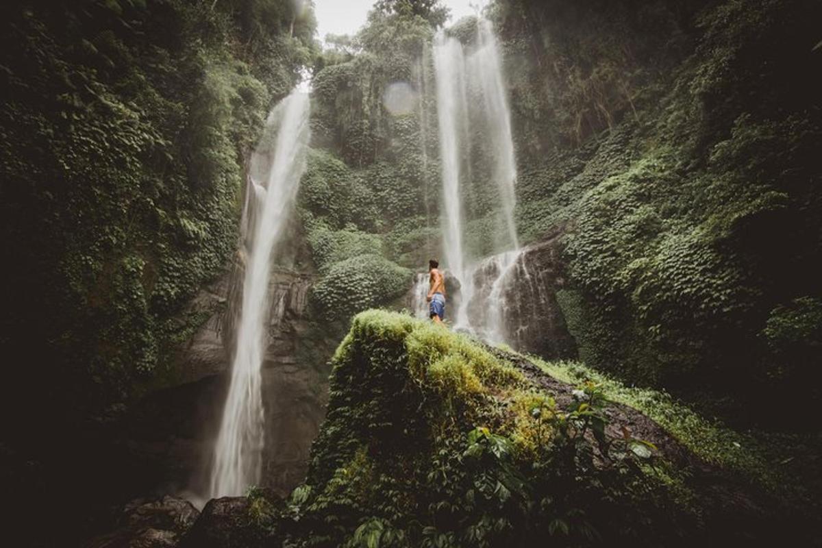 um homem parado em frente a uma cachoeira