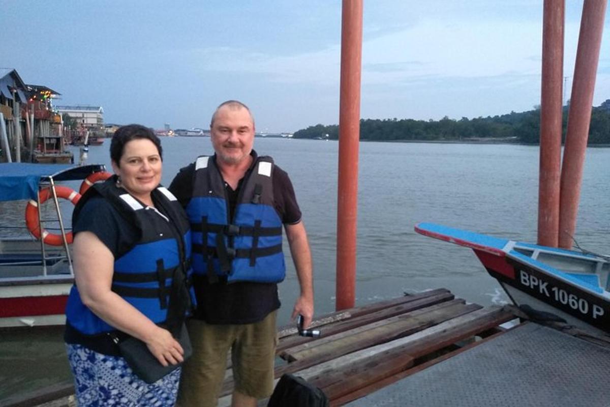 a man and a woman standing next to a boat