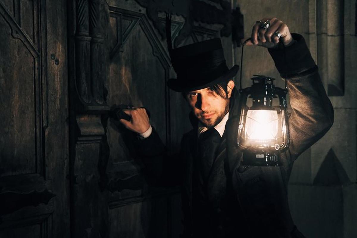 a man in a top hat holding a lamp