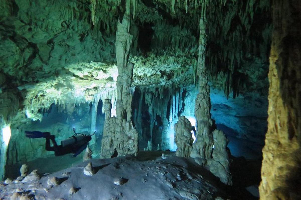 una persona nadando en una cueva con formaciones de hielo