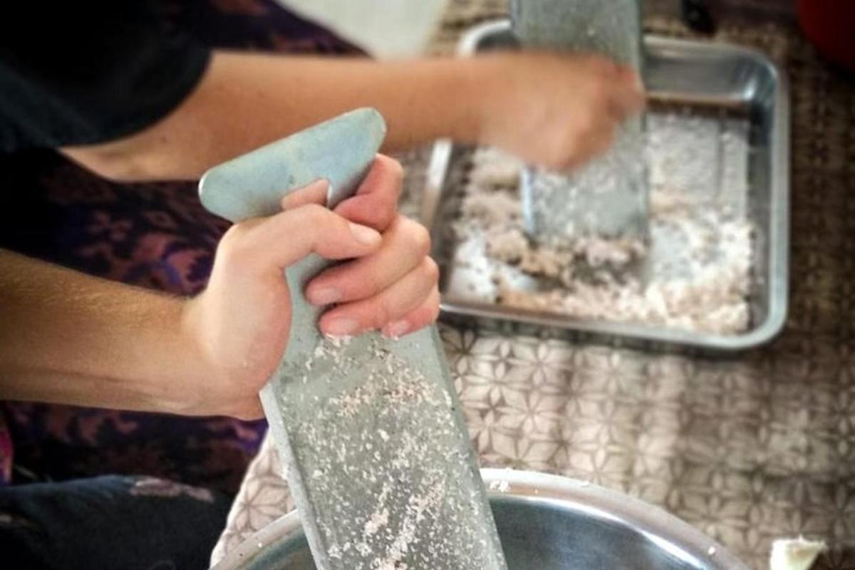 a person holding a spatula in front of a sink