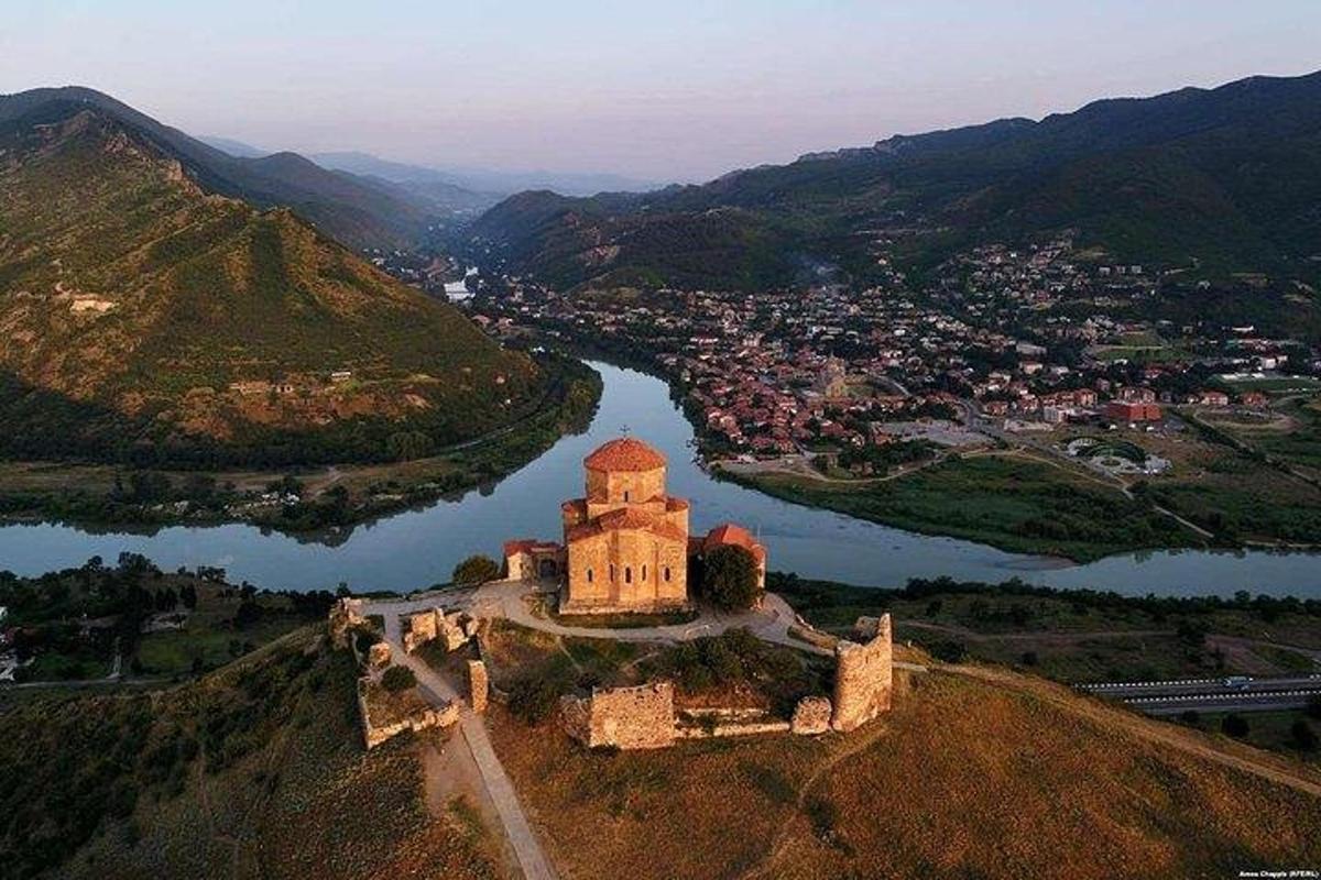 un castello in cima a una collina vicino a un fiume