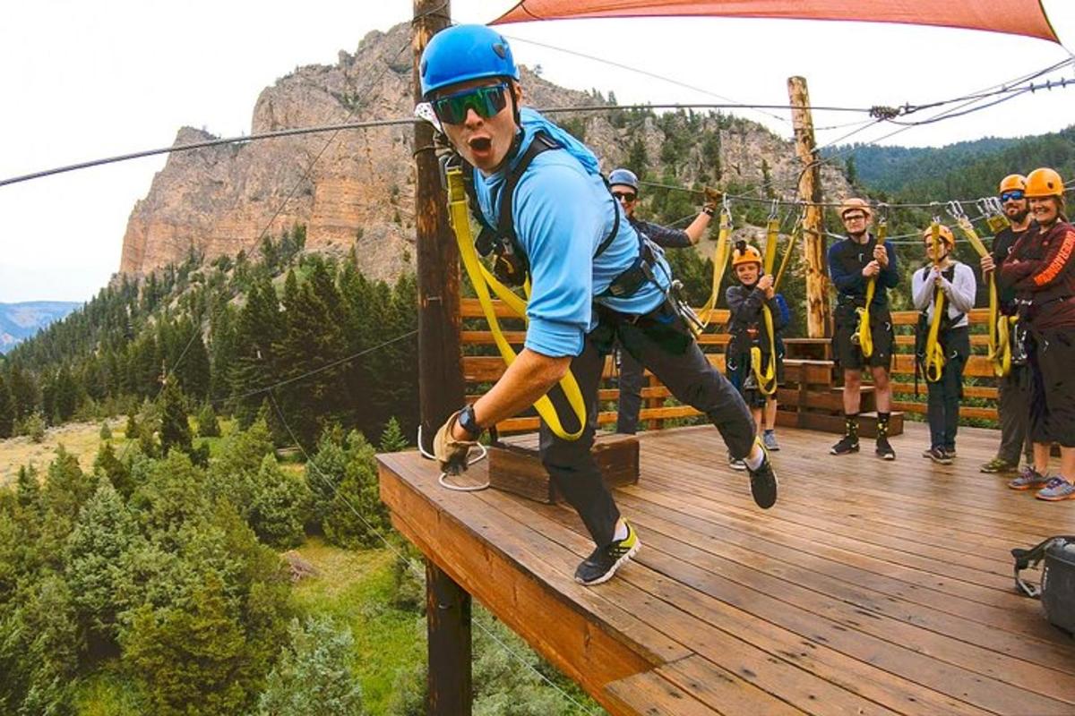 a man on a zip line in the mountains