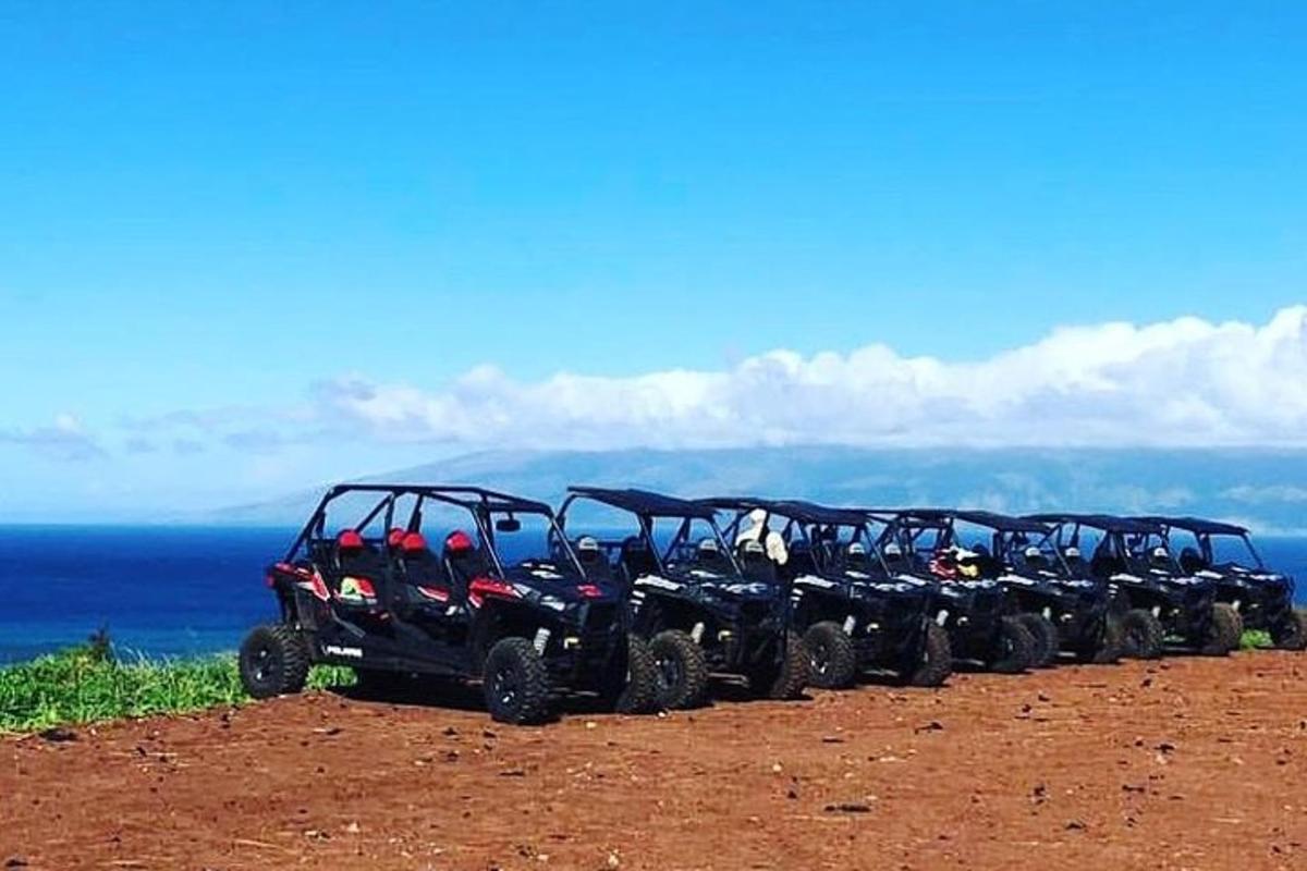 Una fila de cuatro vehículos todo terreno estacionados en la cima de una colina