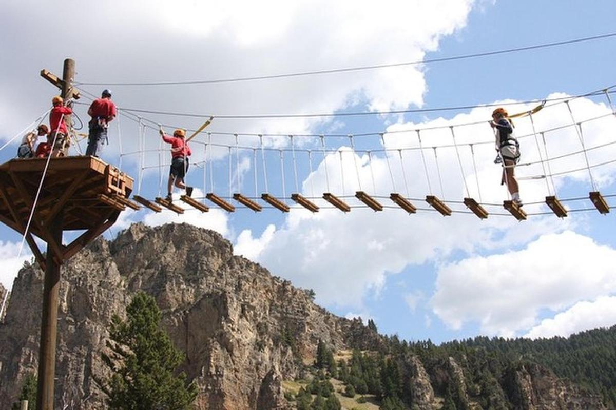 a group of people on a zip line in the mountains