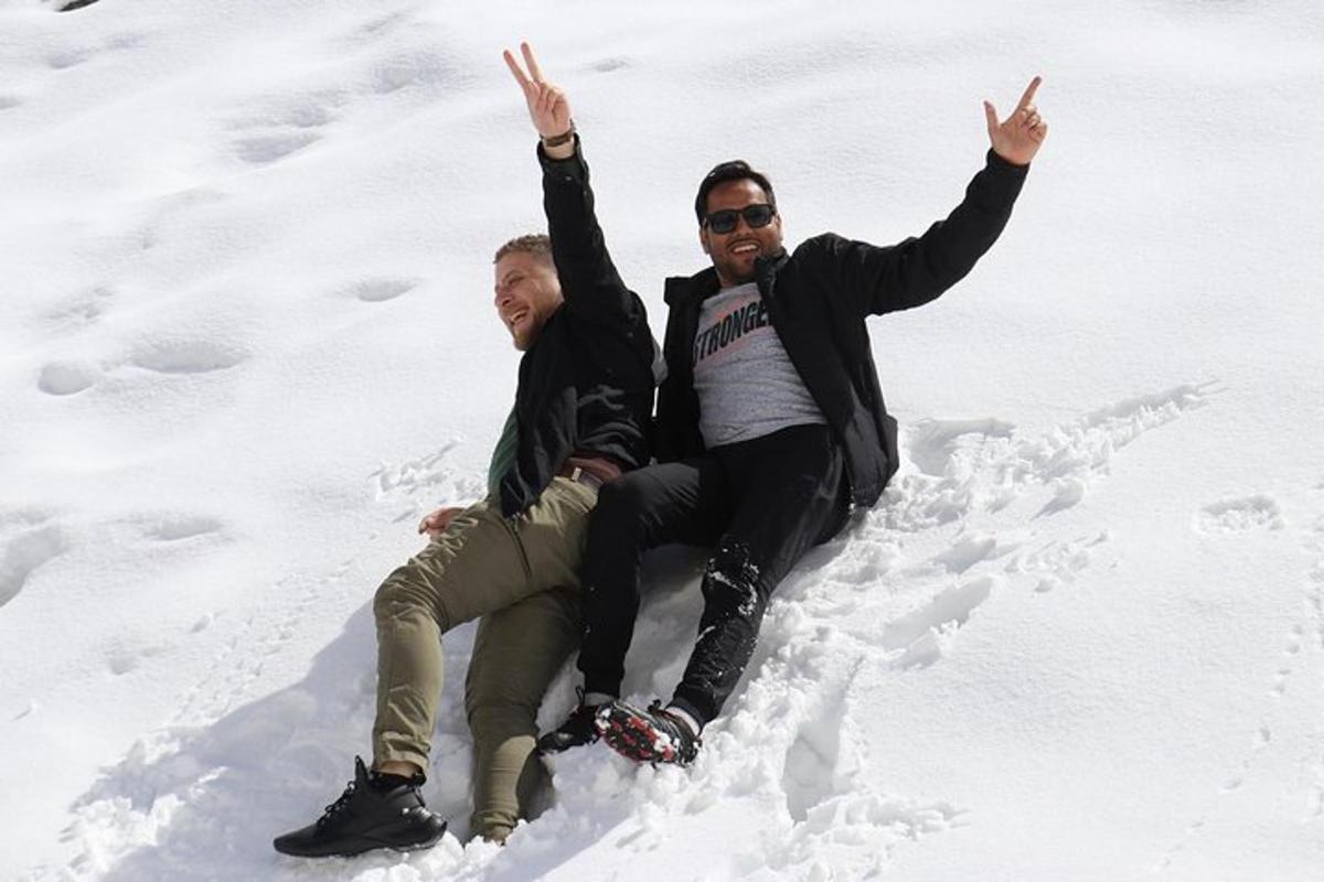 two men are sitting in the snow