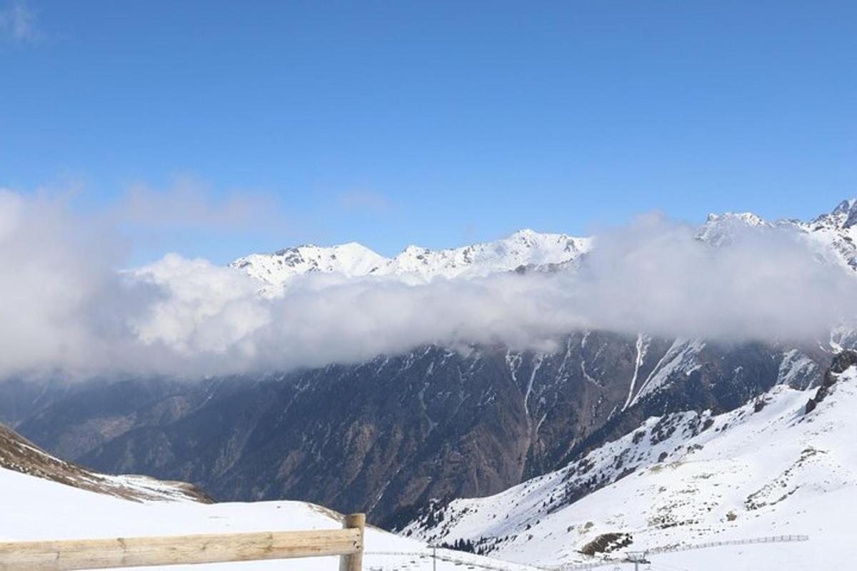 a view of a snow covered mountain range with clouds