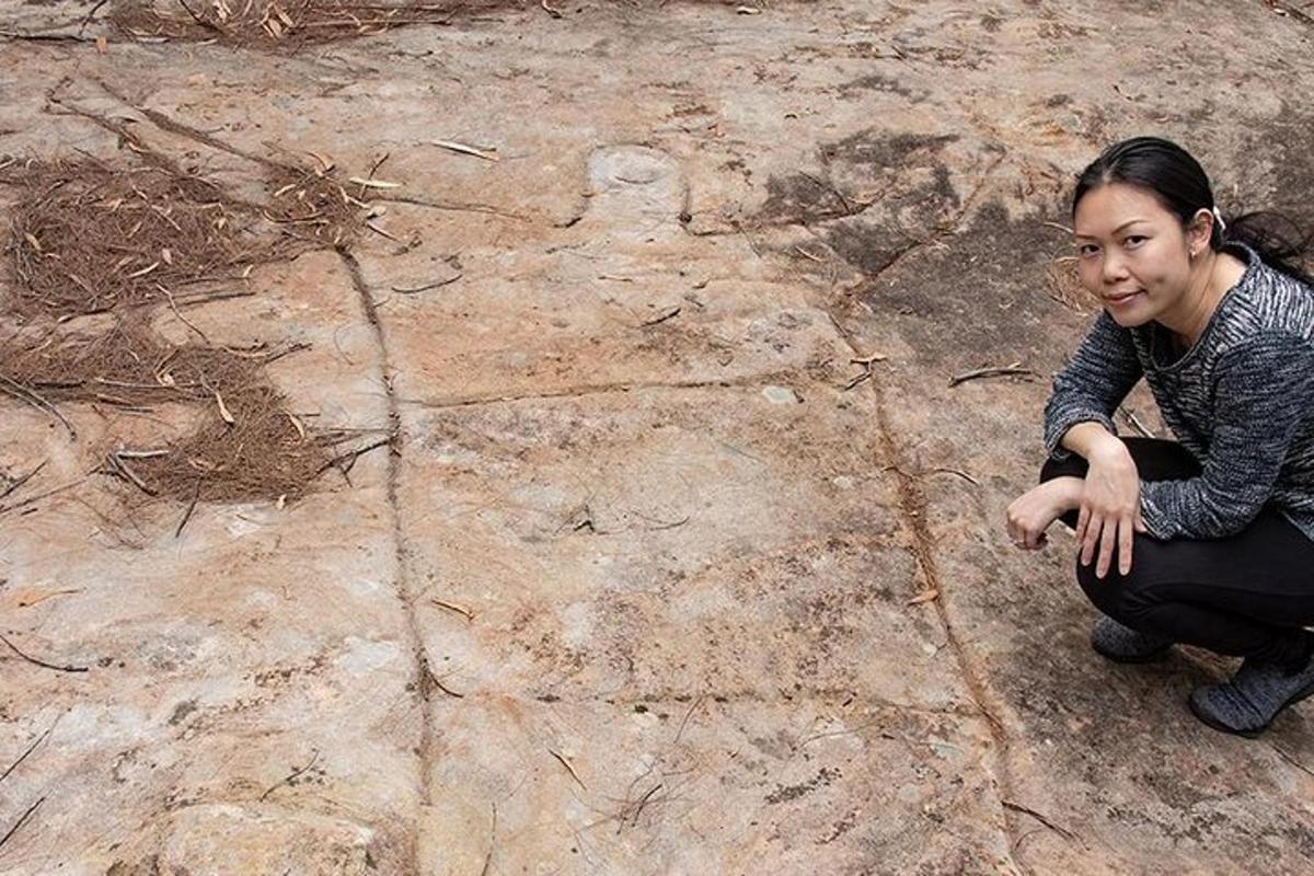 una donna seduta a terra con la mano a terra