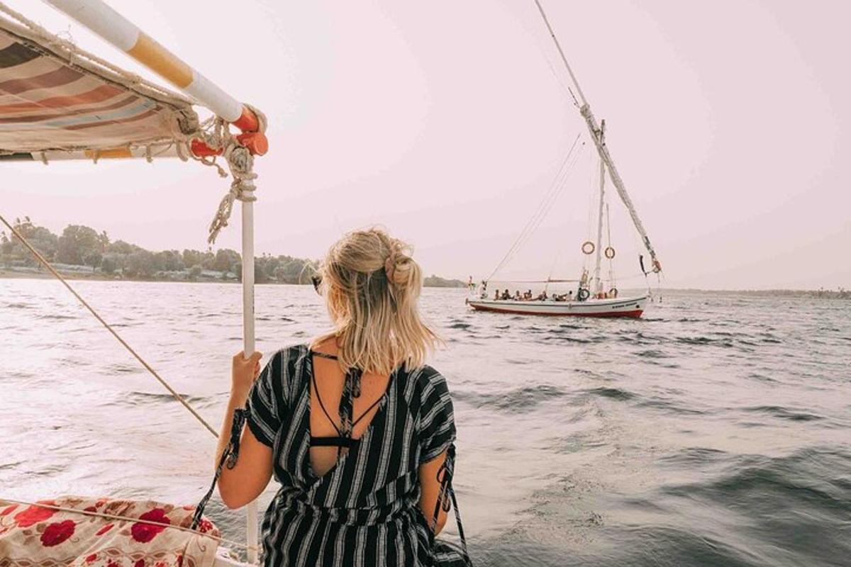seorang wanita di atas bot di dalam air dengan perahu layar