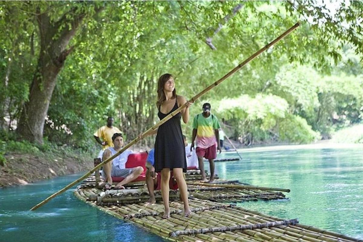 uma mulher está em pé em uma jangada em um rio