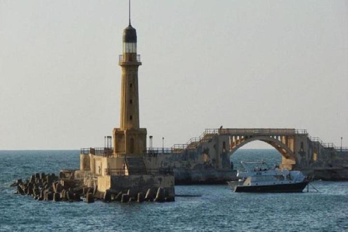 una barca in acqua con un faro e un ponte
