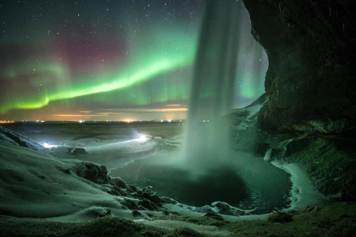 un'immagine di una cascata con l'aurora nel cielo