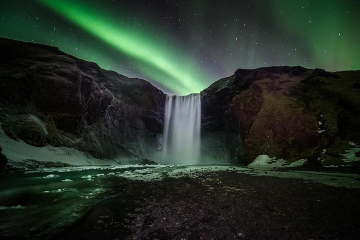 uma imagem de uma cachoeira sob a aurora boreal