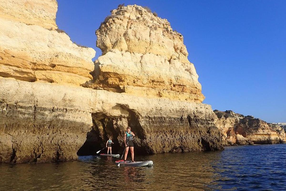 due persone sono in piedi su una tavola da paddle in acqua
