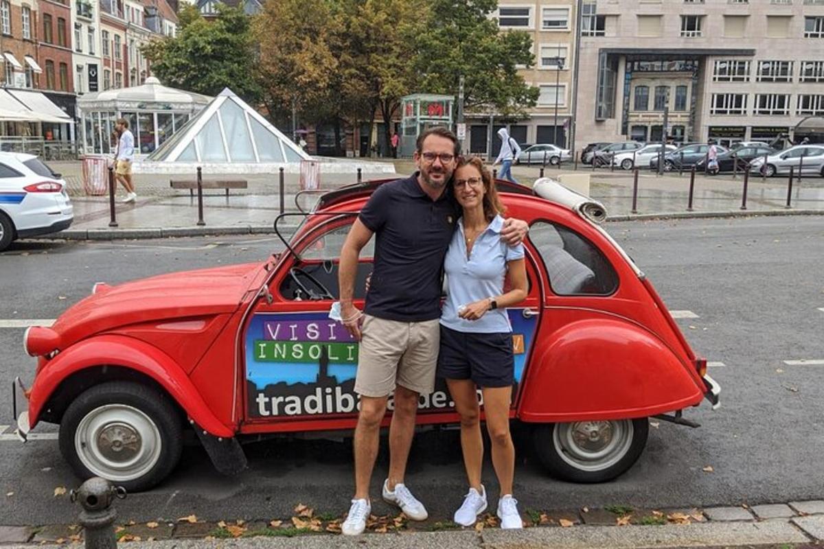 a man and a woman standing next to a small car