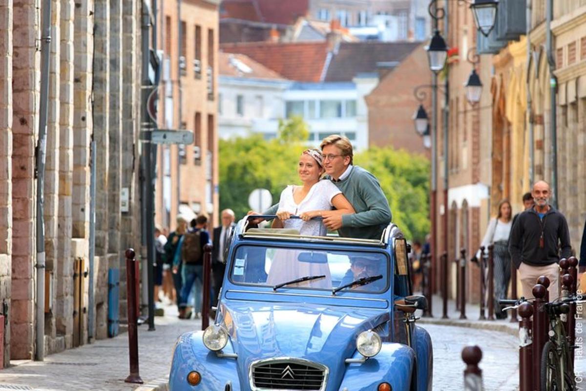 a man and a woman riding in an old car
