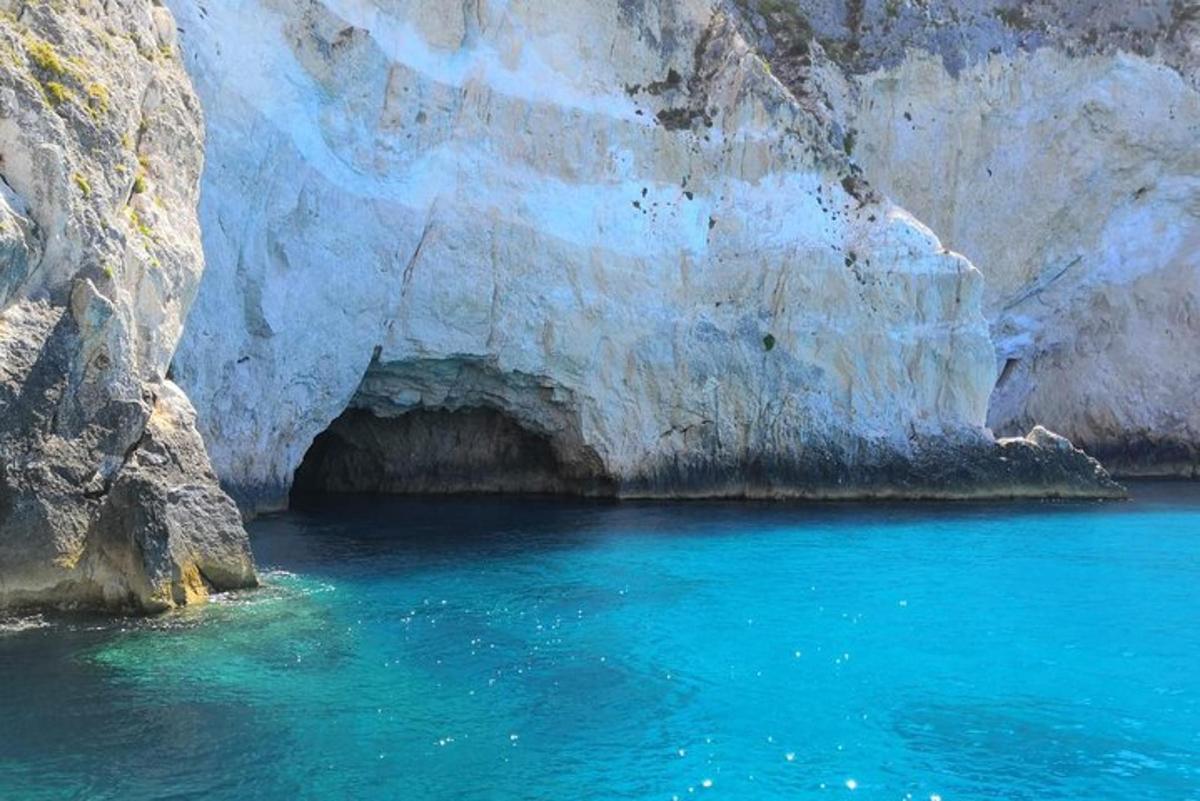 un bassal d'aigua blava al costat d'un penya-segat rocós