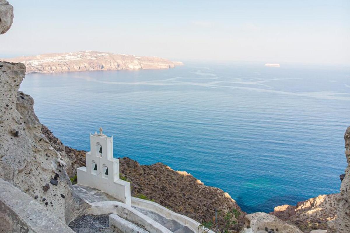 μια λευκή εκκλησία σε έναν απότομο βράχο δίπλα στον ωκεανό