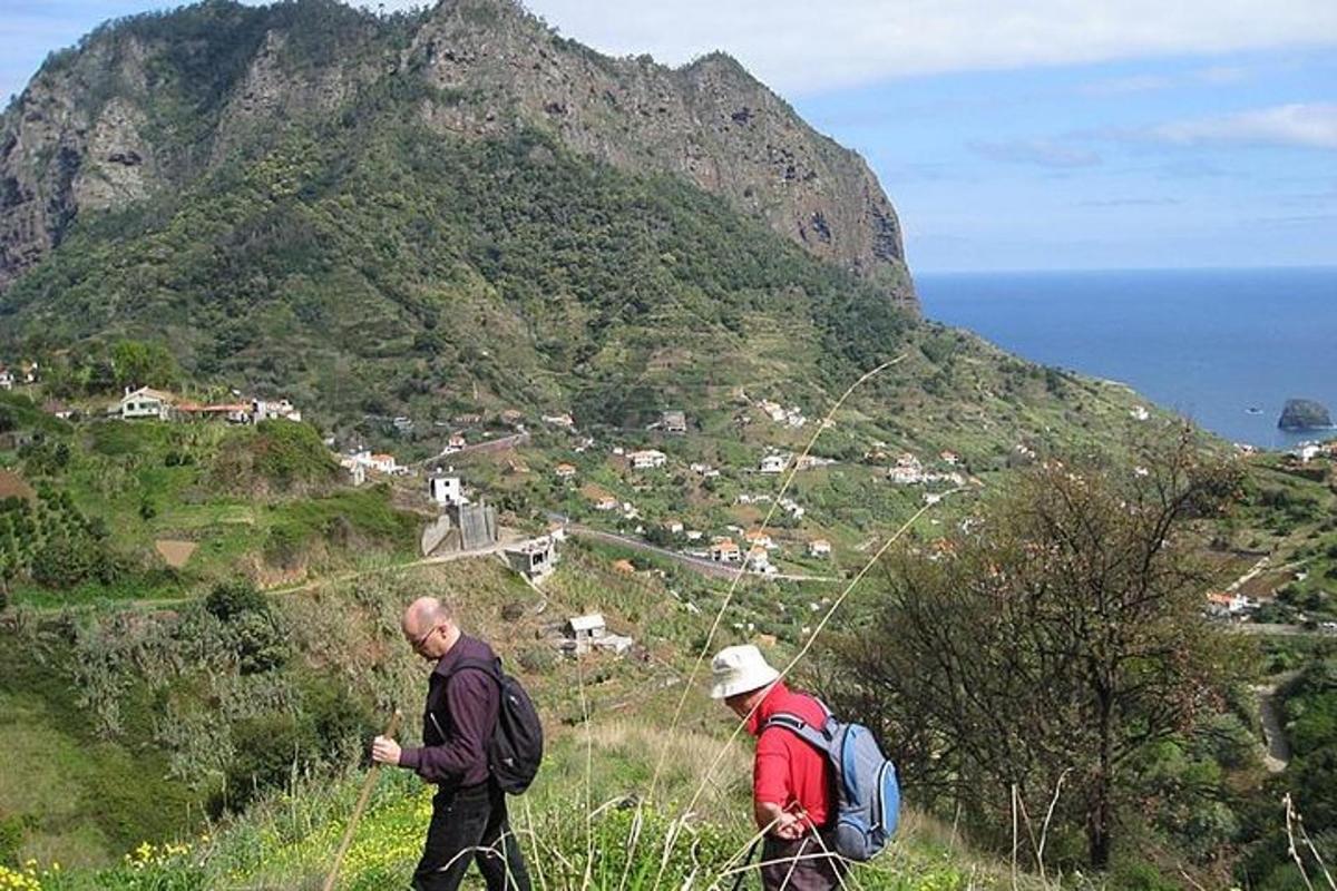 dois homens caminhando em uma colina com uma montanha