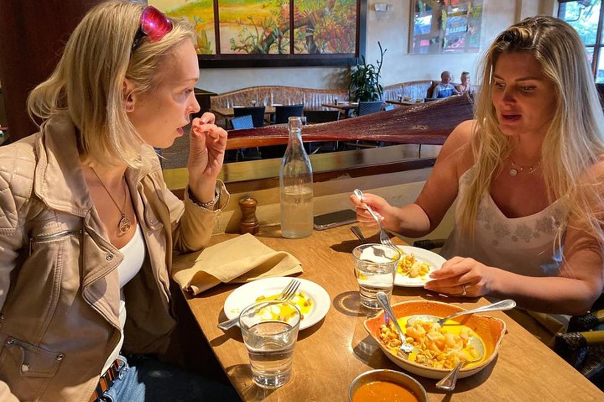 two women sitting at a table eating food