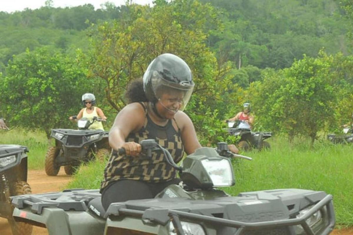 una mujer conduciendo una motocicleta por un camino de tierra